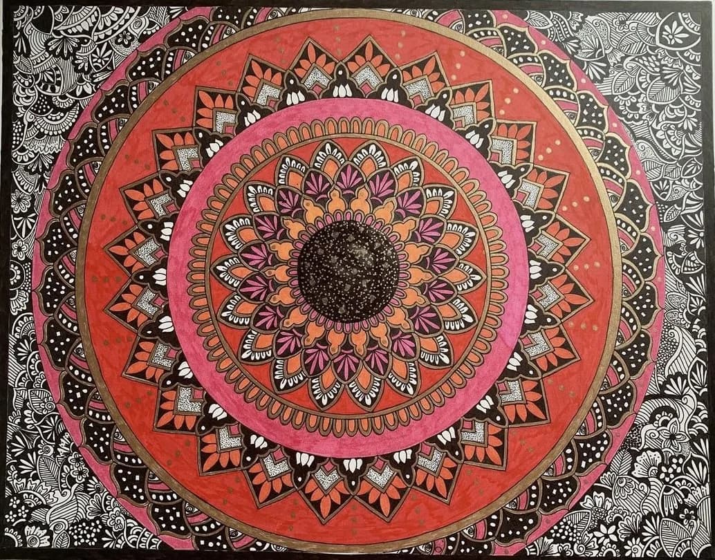 A large mandala in red, pink and gold, surrounded by black and white line work