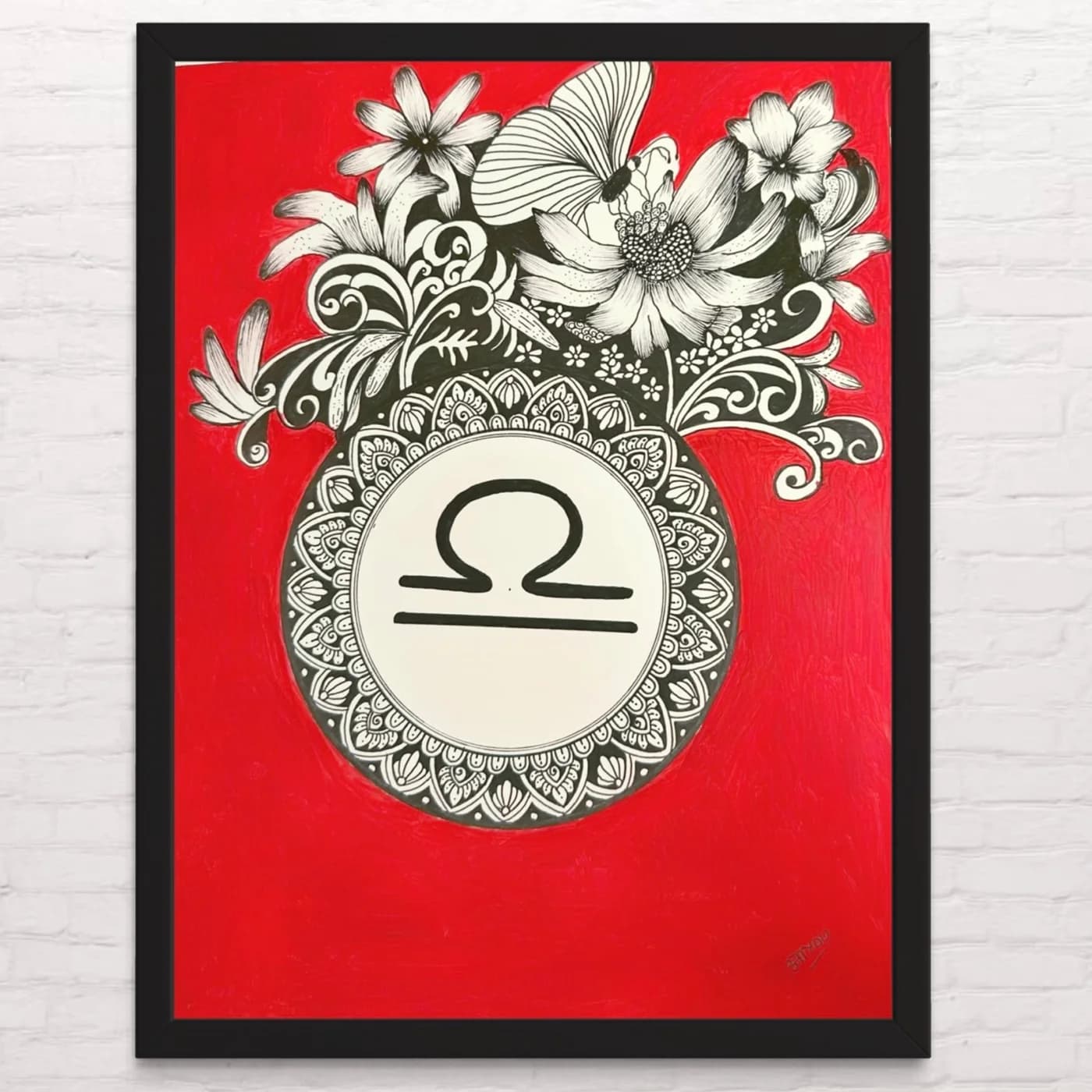 Libra sign in a mandala beneath flowers, on a red background