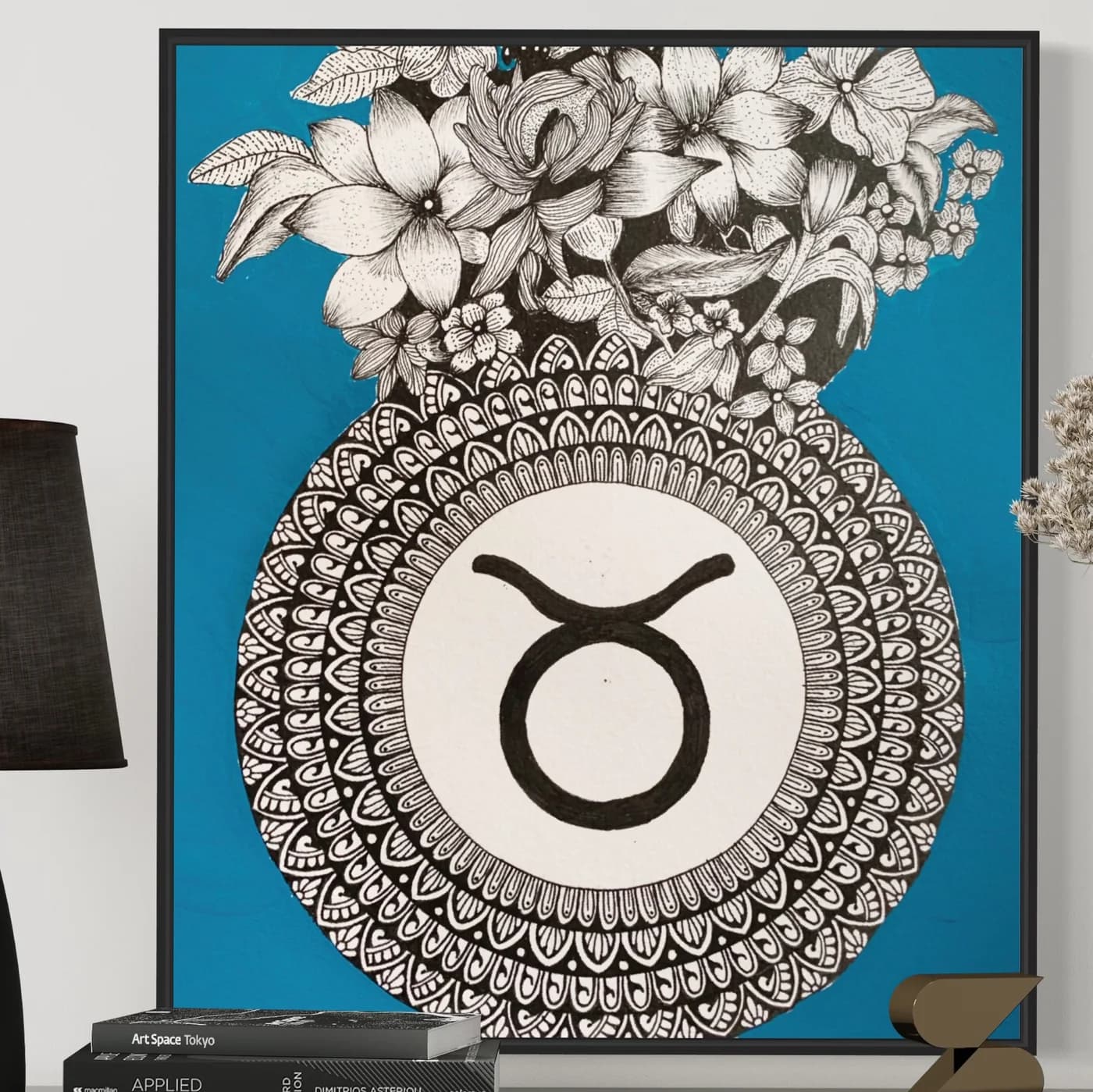 Taurus sign in a mandala beneath flowers, on a blue background